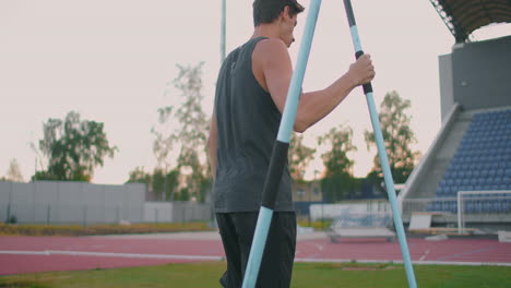 Cámara-Lenta:-Un-Atleta-Masculino-En-El-Estadio-Se-Concentra-Y-Se-Prepara-Para-Hacer-Un-Lanzamiento-De-Jabalina.-Actitud-Y-Expresión-Seria.-Anda-Recogiendo-Lanzas.-Entrenamiento-De-Un-Lanzador-De-Jabalina